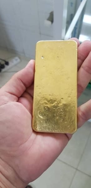A verified gold bar checked by hand